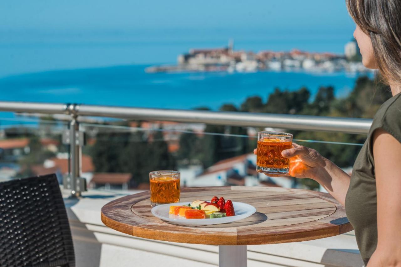 Hotel Iberostar Slavija Budua Esterno foto A woman holding a glass of orange juice